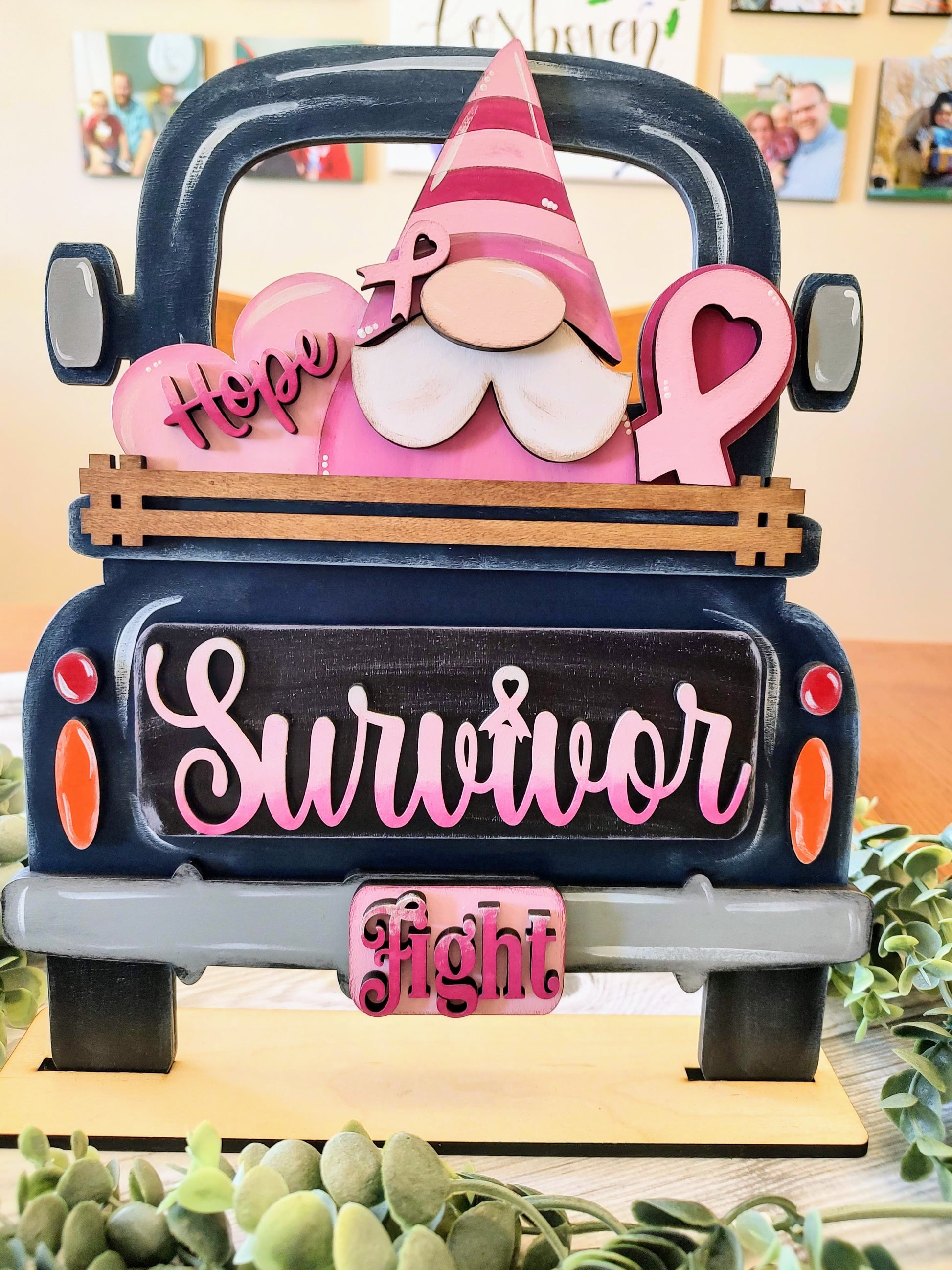 A decorative wooden sign shaped like the back of a dark blue truck, featuring a pink-and-white striped gnome with a party hat, pink heart shapes, and the words 'Hope', 'Survivor', and 'fight'.